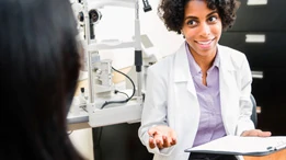 Woman smiling while explaining an eye test to patient