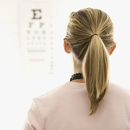 adult female patient in doctor's office looking at eye chart