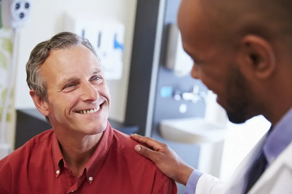 Male Patient Being Reassured By LASIK surgeon