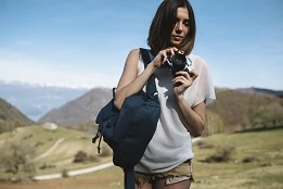 woman holding camera and backpack