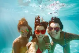 Underwater selfie of happy females in pool
