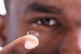 Close-up Of A Man Holding Transparent Contact Lens In His Finger